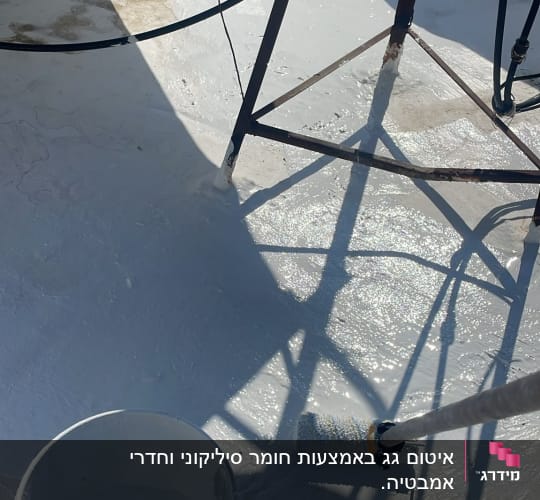 דלי צבע ורולר על גג לבן